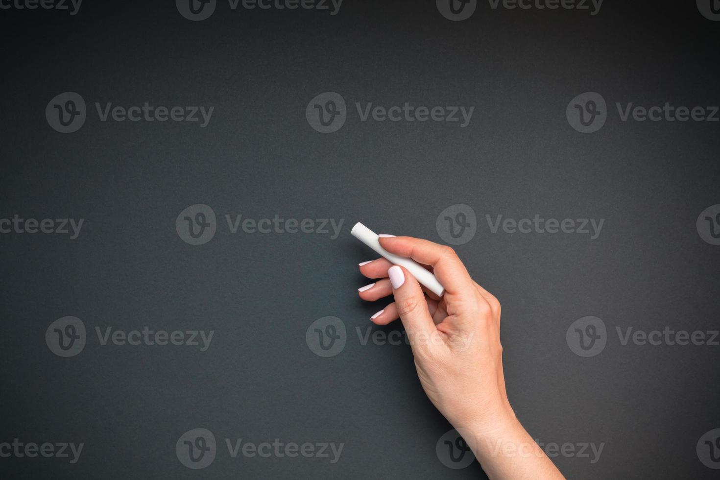 Teacher hand with piece of chalk photo