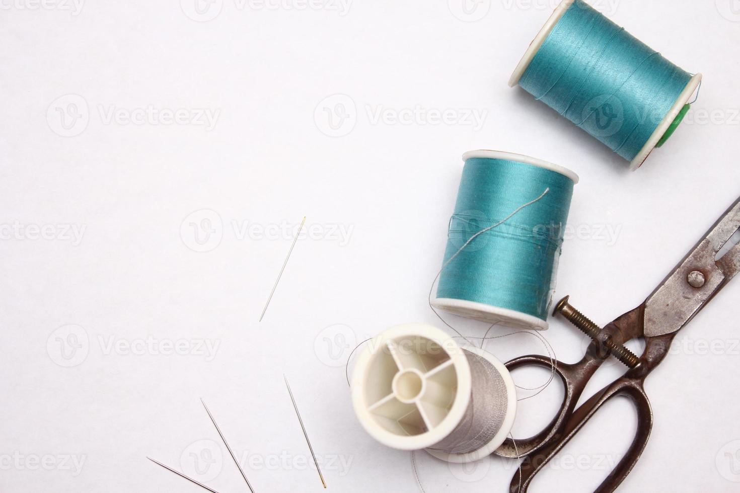 Multi-colored threads and old scissors spread out on a white floor, retro scissors, flat lay, copy space. photo