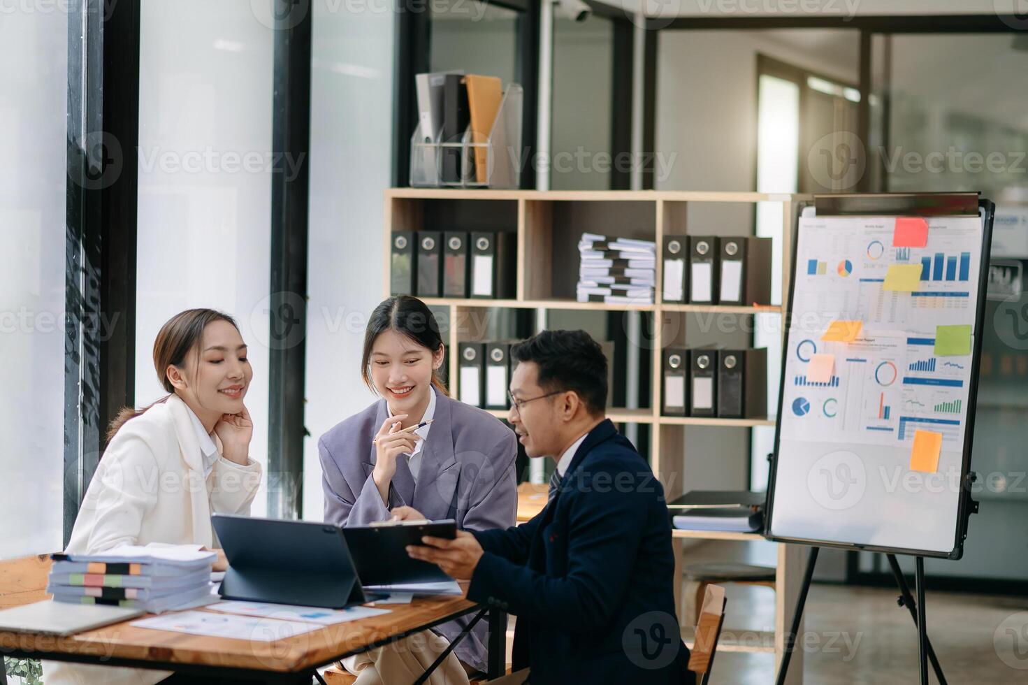 Group of young Asian business people discussing business plan at modern startup in creative business discussing work modern office building photo