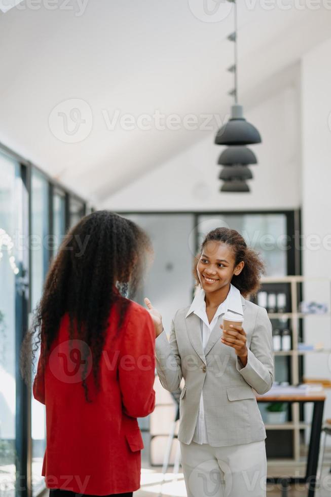 Two Asian businesswoman discuss investment project working and planning strategy with tablet laptop computer in modern office. photo