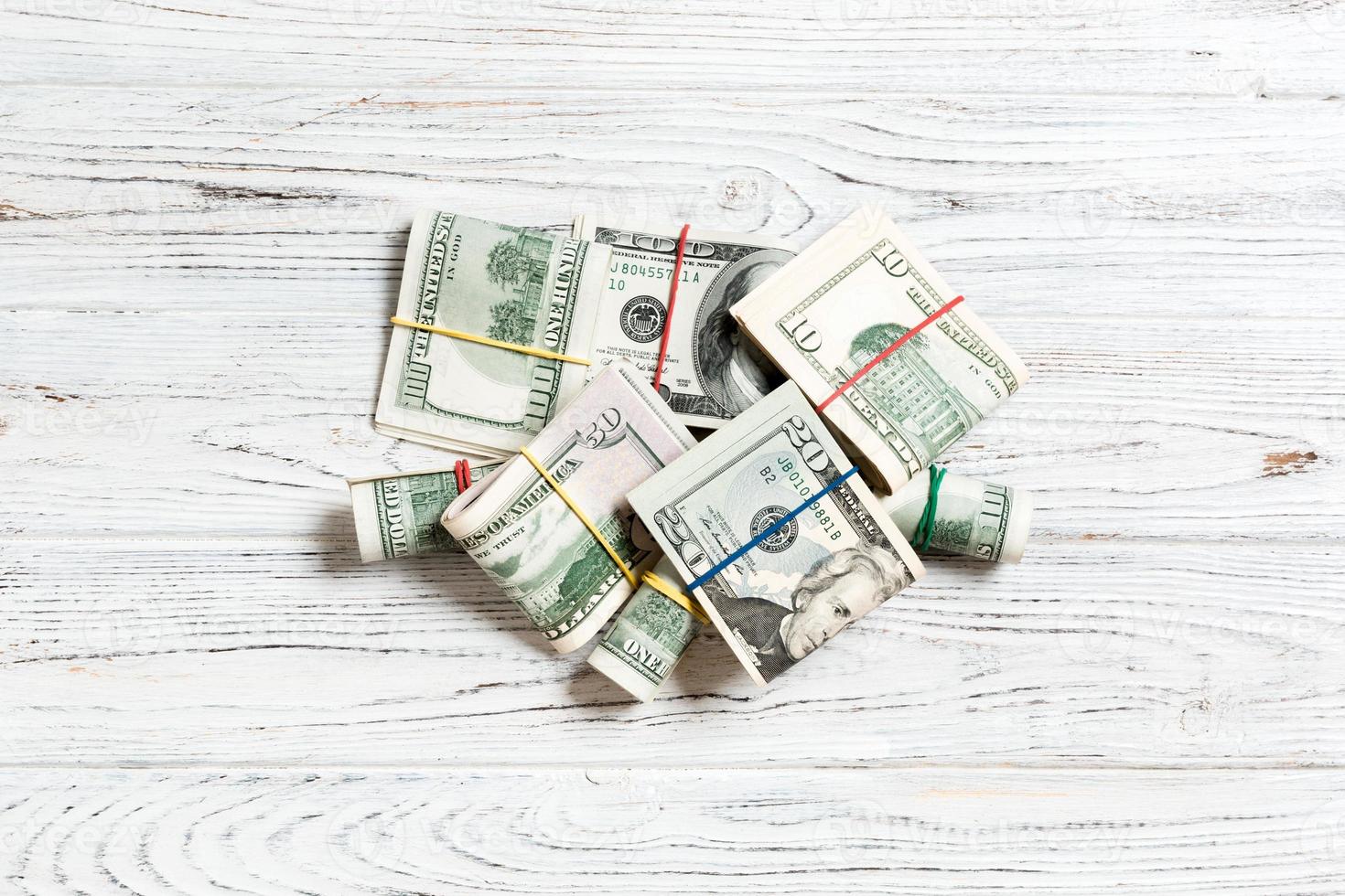 Stacks of one hundred dollars banknotes close-up on colored background business concept top view with copy space photo