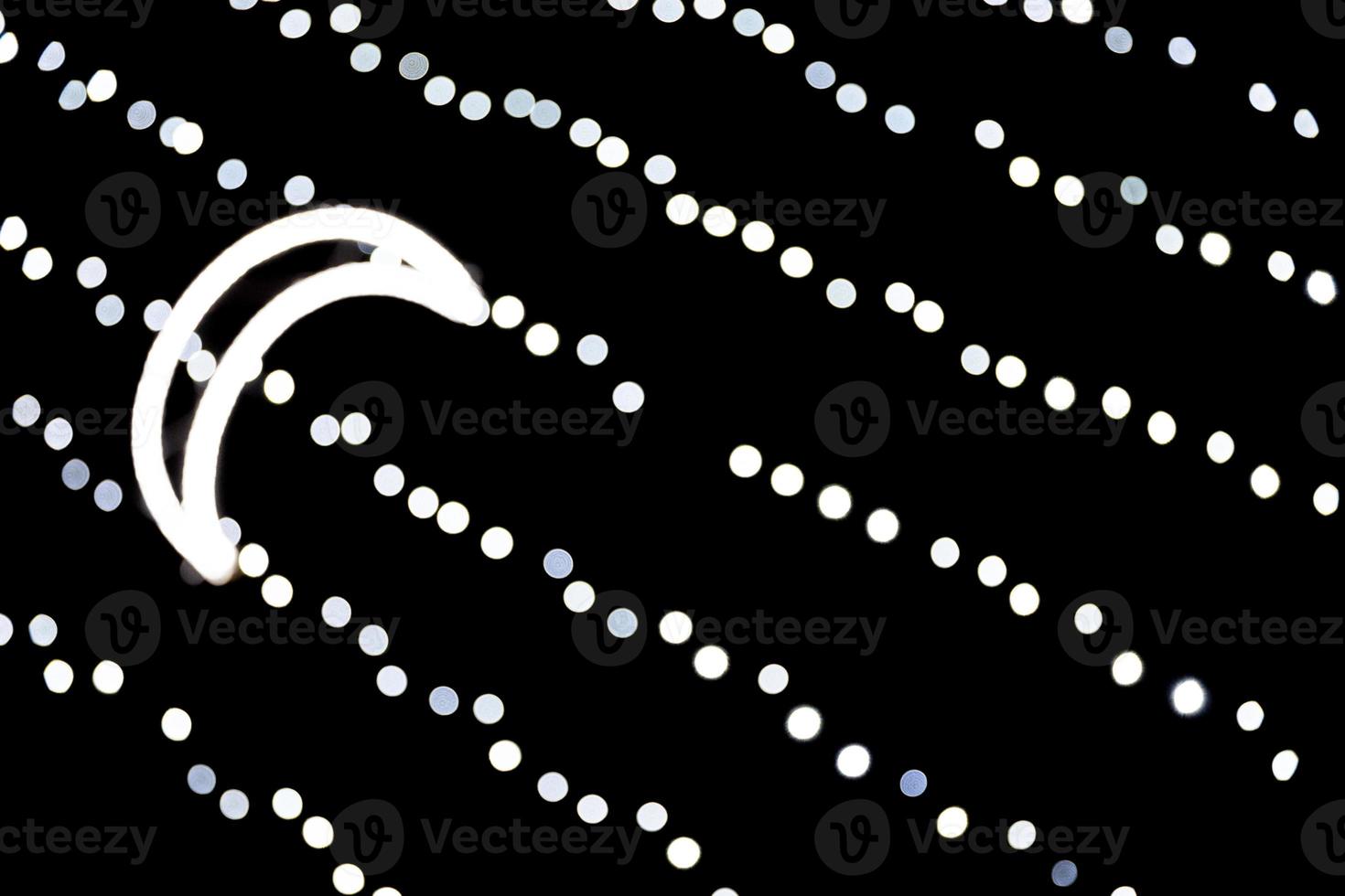 Abstract bokeh of white city lights on black background. defocused and blurred with moon of lights photo