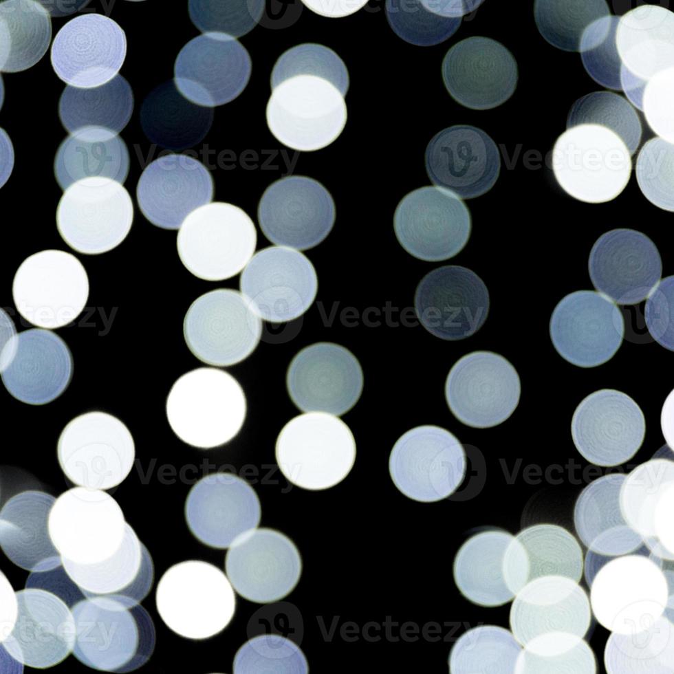 Unfocused abstract white bokeh on black background. defocused and blurred many round light photo