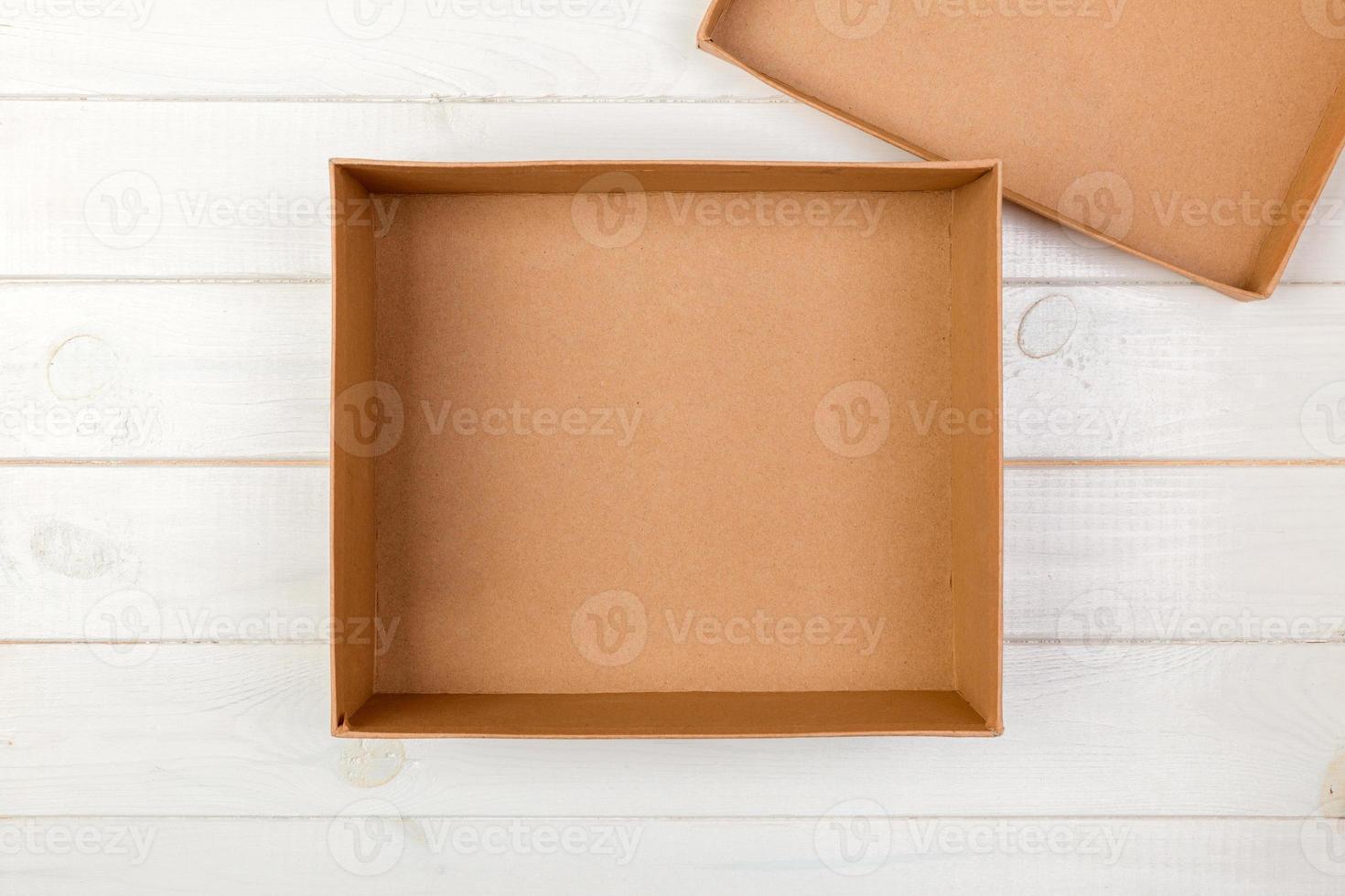Opened empty cardboard box on wooden background. Top view photo