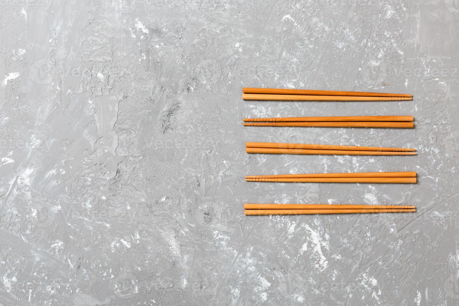 Many bamboo chopsticks on black cement stone background, top view with copy space. a lot of sushi sticks in the form of an ornament photo