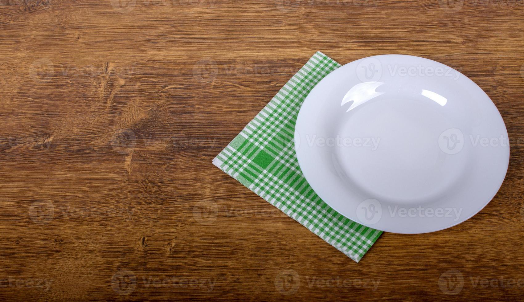 Top view of clean empty plate on wooden tabletop photo