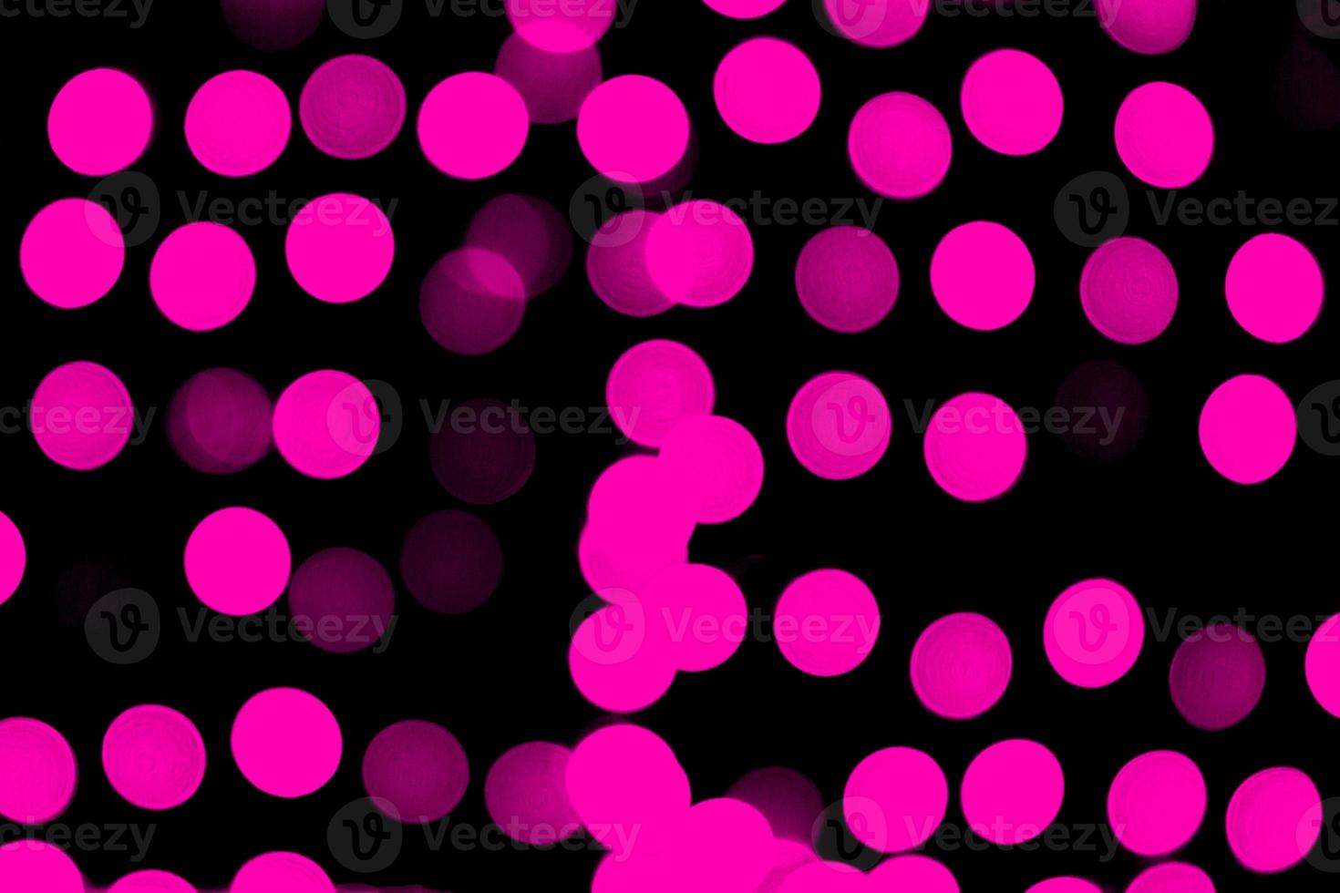 Bokeh rosa abstracto desenfocado sobre fondo negro. desenfocado y borroso muchas luces redondas foto