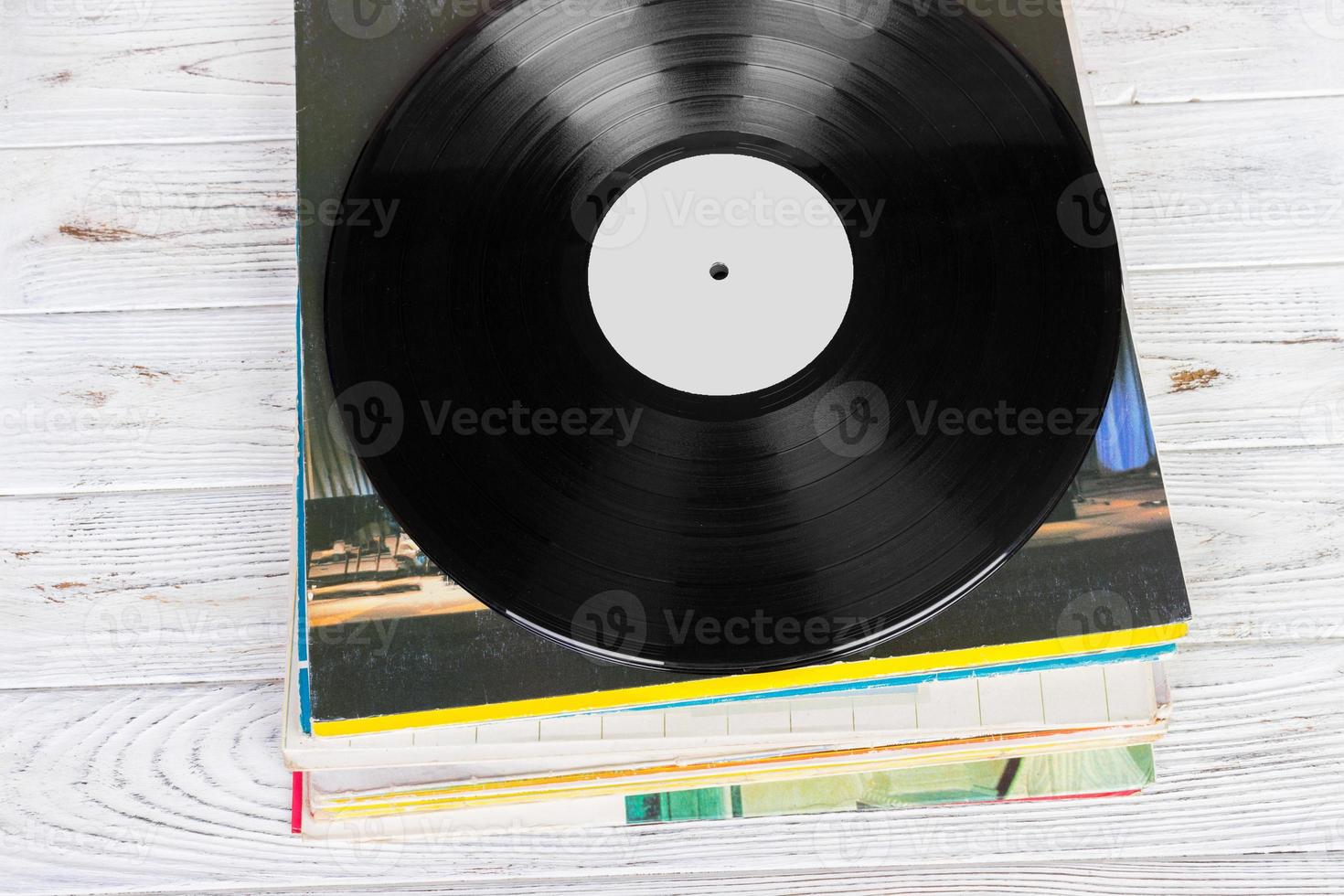 Black vinyl records on the wooden table, selective focus with copy space. Top view photo
