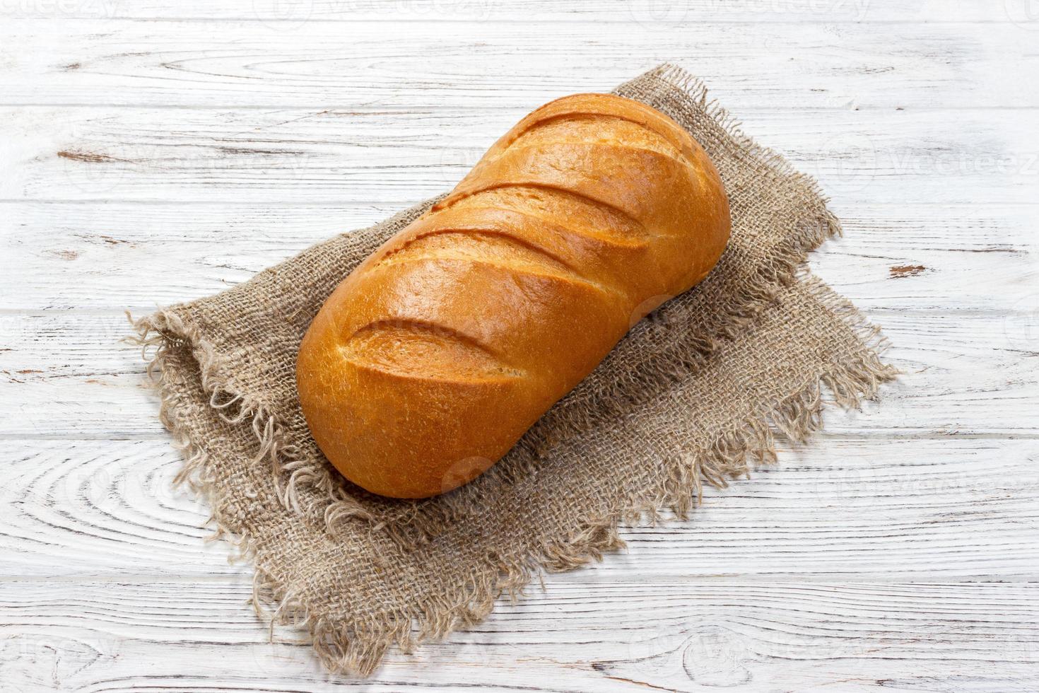 Fresh bread on wooden table. Top view with space for text photo