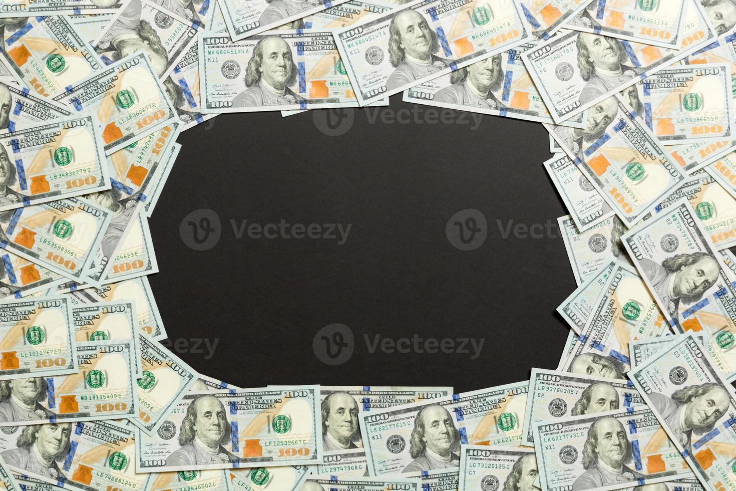 Frame of one hundred dollar bills with empty space for your design. Top view of business concept on black background with copy space photo