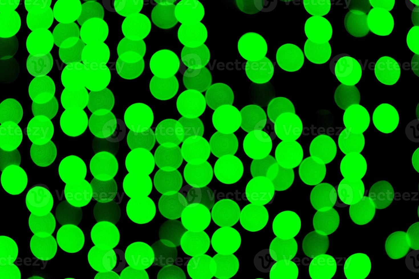 Unfocused abstract green bokeh on black background. defocused and blurred many round light photo