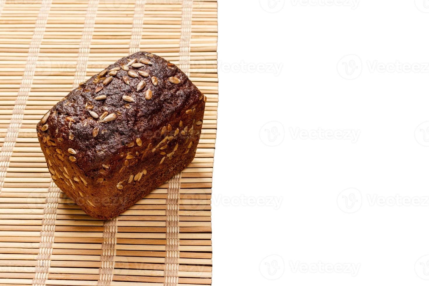 Toasty Organic Loaf of rye Bread on wooden plank isolated on white photo