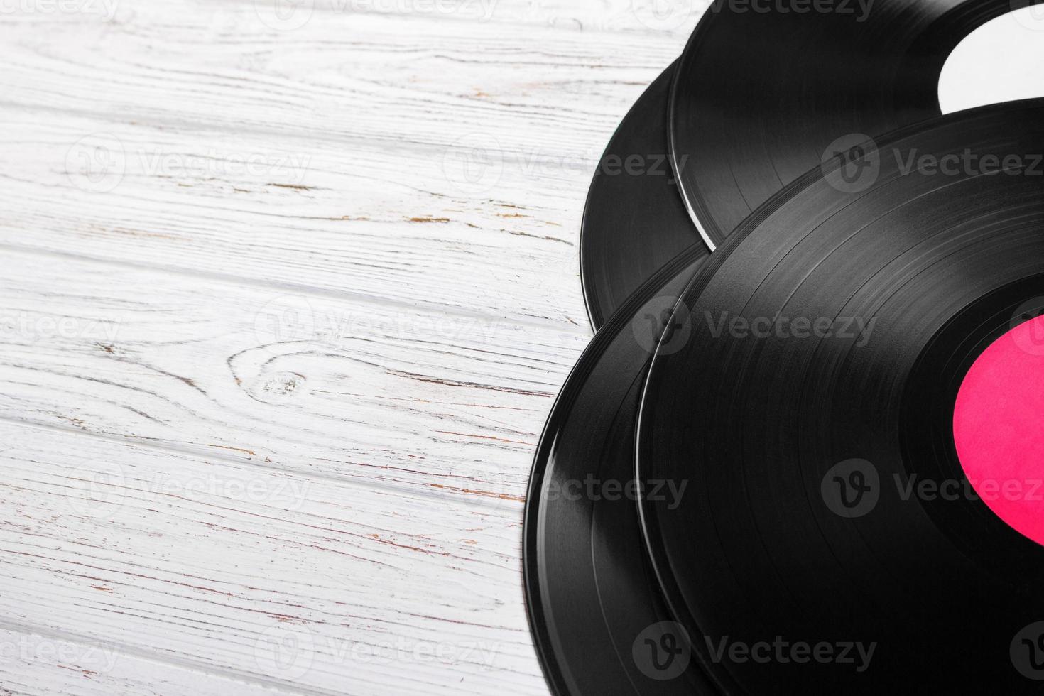 Top view of vinyl records stack over light wooden table with copy space for text photo