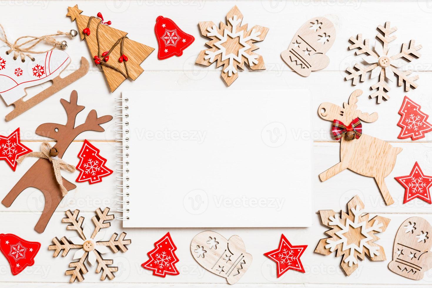 Top view of notebook on wooden background made of Christmas decorations. New Year concept photo