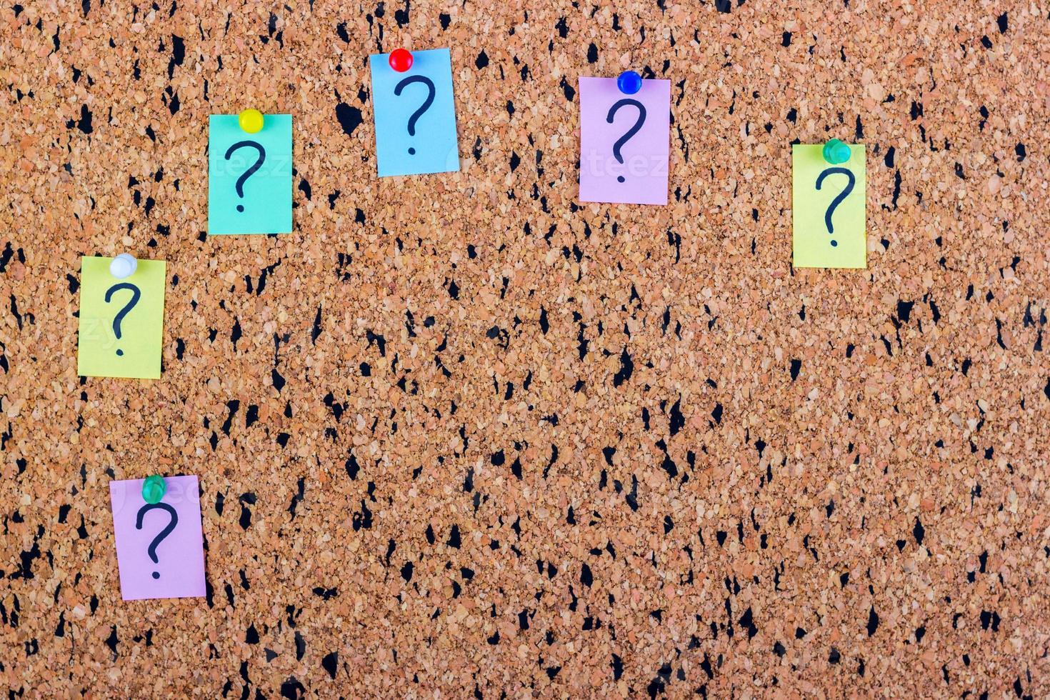 uncertainty or doubt concept, question mark on a sticky note on cork bulletin board photo