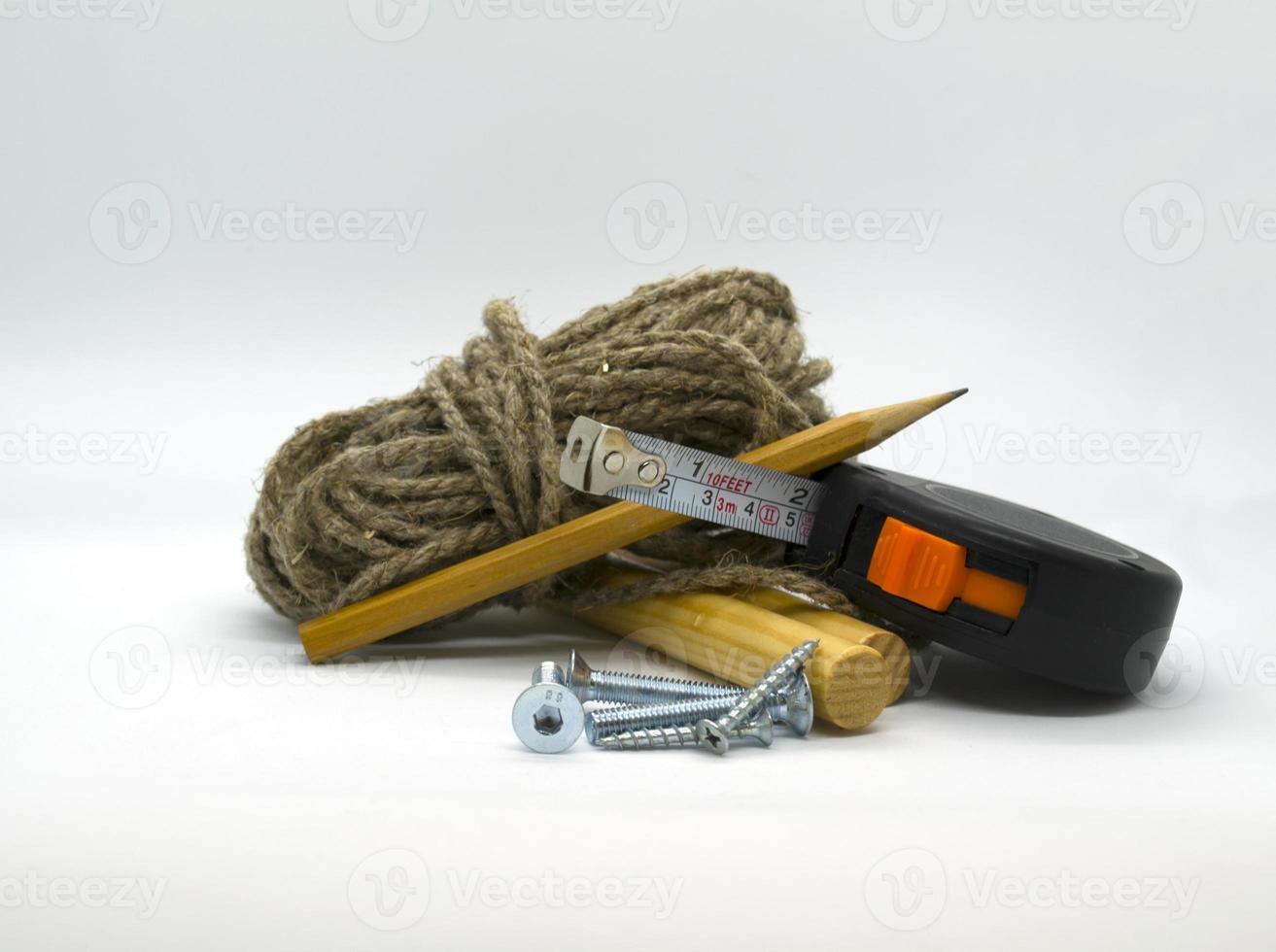 Nails, pieces of wood, construction ruler, pencil and twine photo