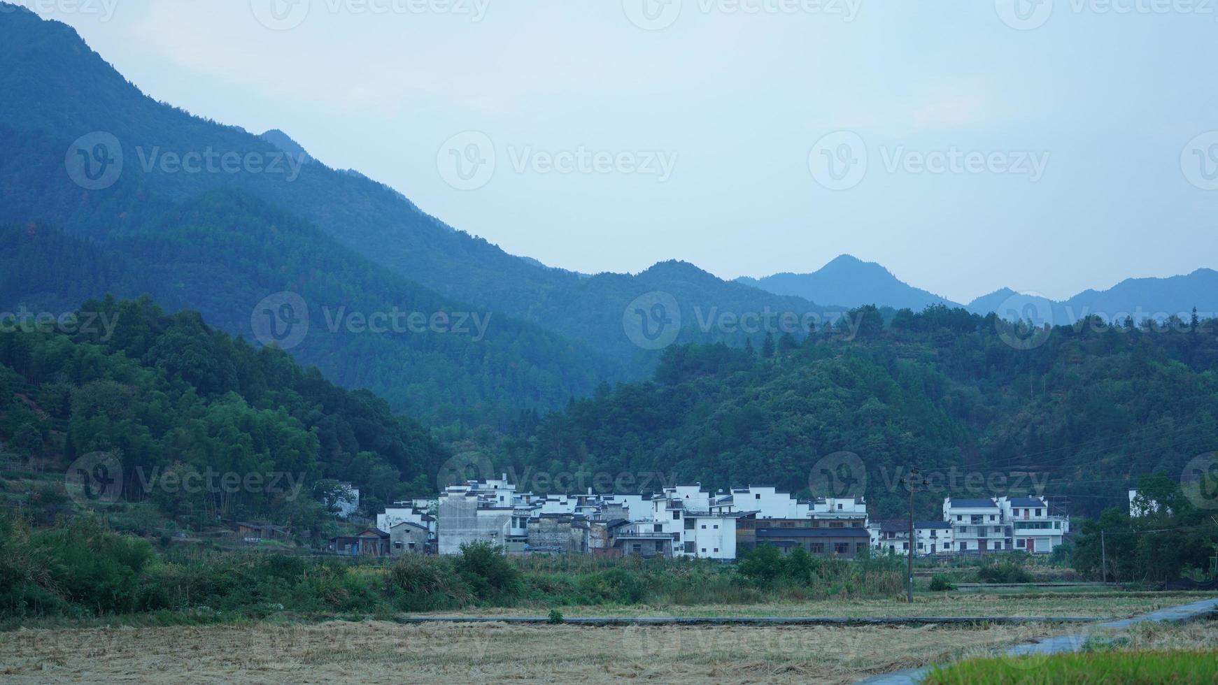 The beautiful traditional Chinese village view with the classical architecture and fresh green trees as background photo