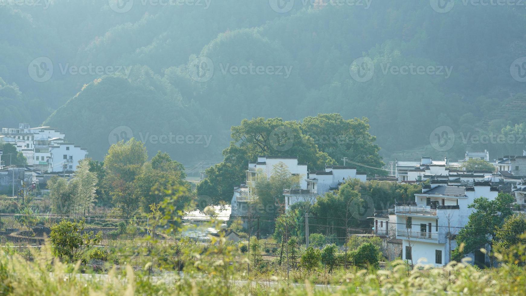 The beautiful traditional Chinese village view with the classical architecture and fresh green trees as background photo