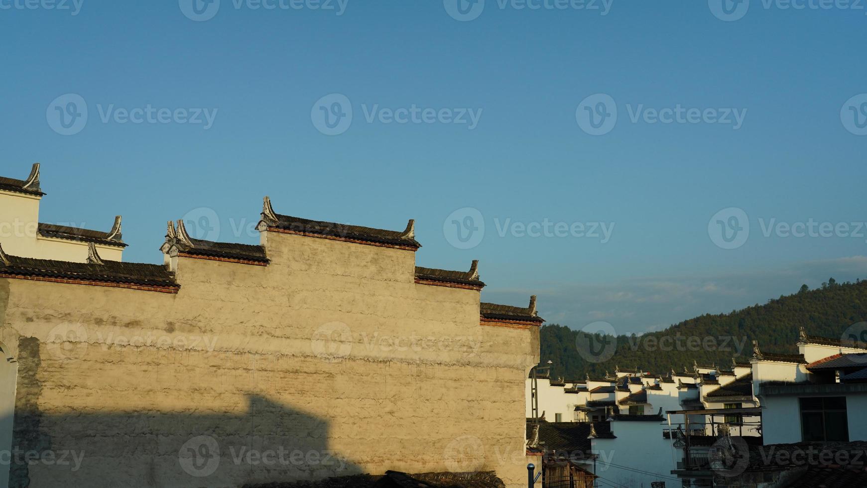The beautiful traditional Chinese village view with the classical architecture and fresh green trees as background photo