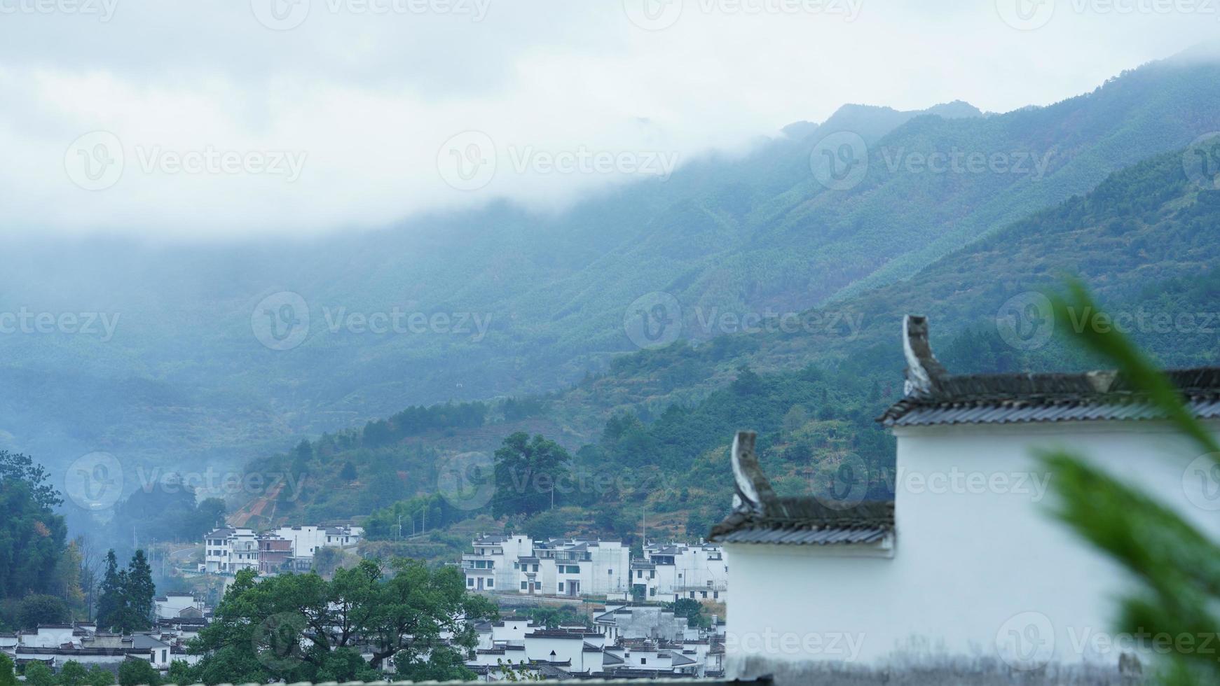 The beautiful traditional Chinese village view with the classical architecture and fresh green trees as background photo