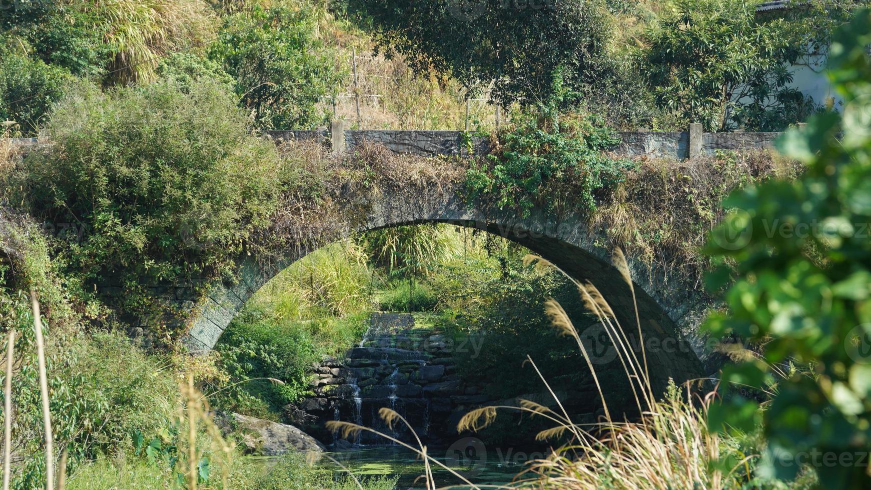 The old arched stone bridge view located in the countryside of the China photo