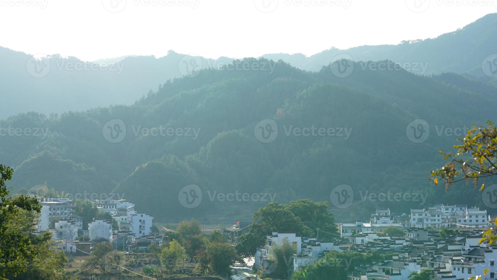 The beautiful traditional Chinese village view with the classical architecture and fresh green trees as background photo