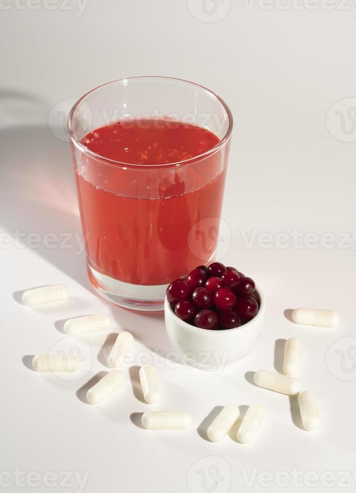 Glass of cranberry juice, cranberries, vitamins. photo