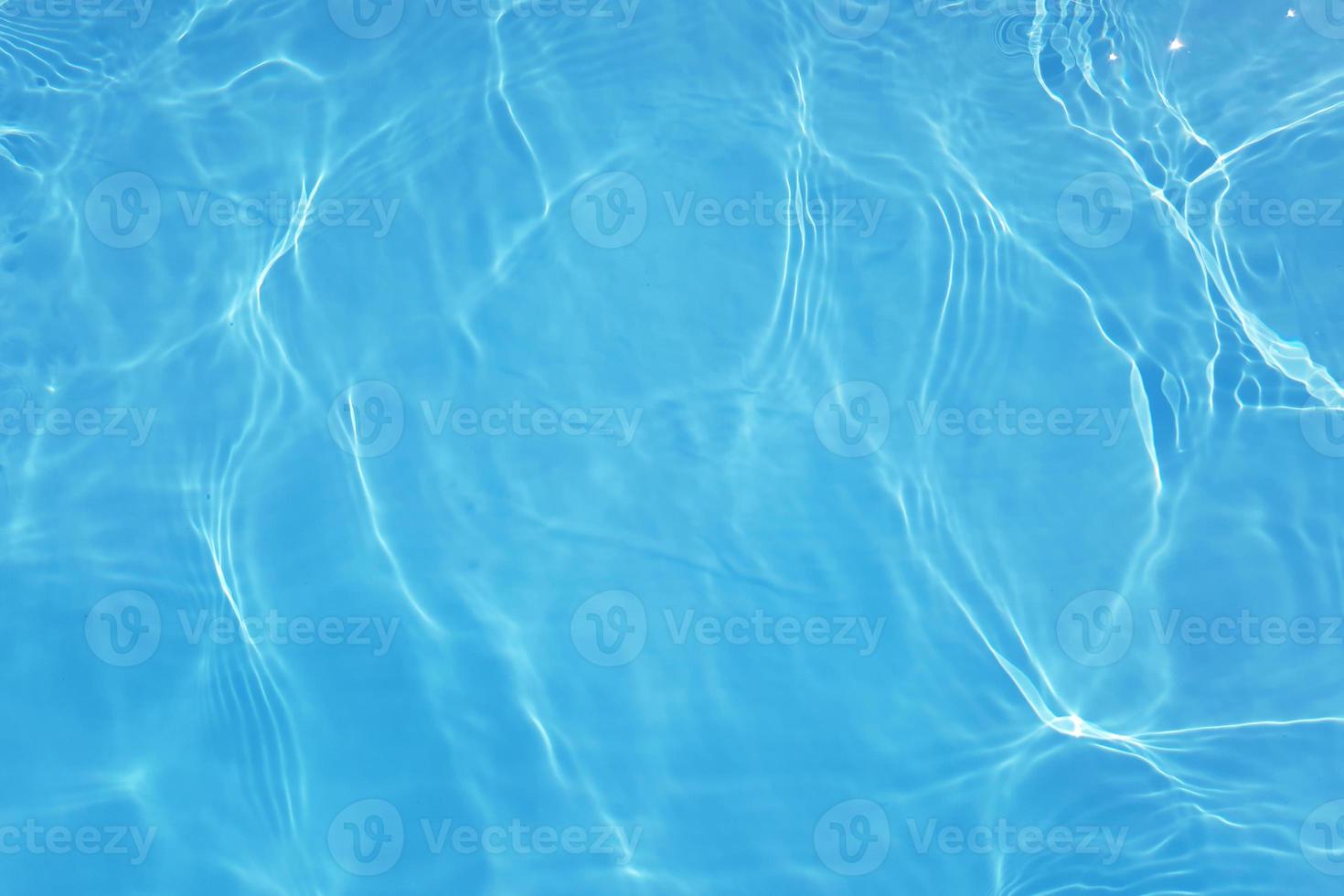 Defocus blurred transparent blue colored clear calm water surface texture with splashes and bubbles. Trendy abstract nature background. Water waves in sunlight with copy space. Blue watercolor shining photo