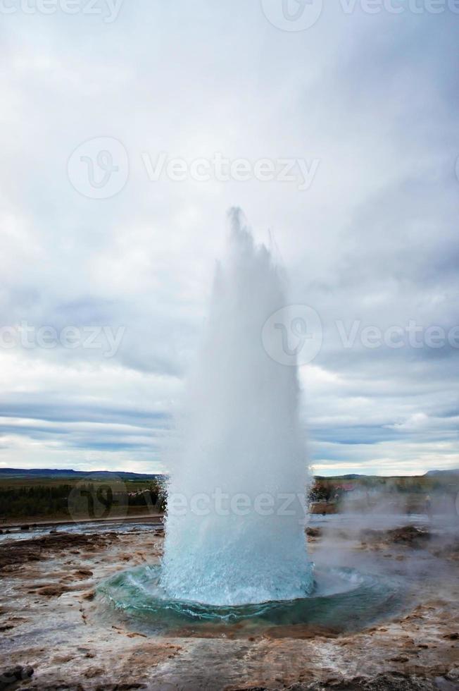 The Great Geysir, geyser in southwestern Iceland, Haukadalur valley. Geyser splashing out of the ground against the background of a cloudy sky photo