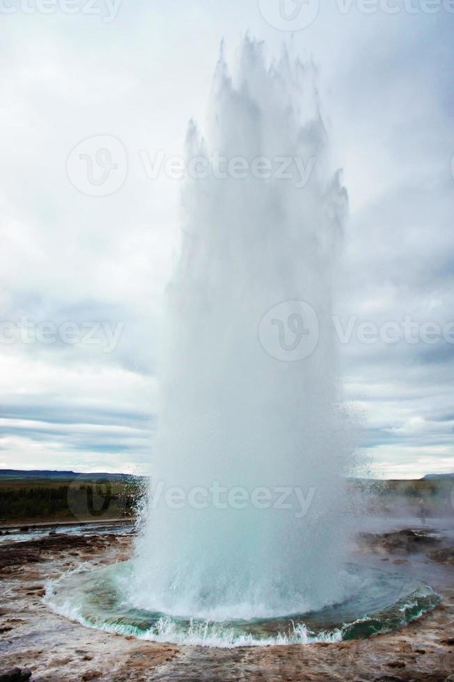 The Great Geysir, geyser in southwestern Iceland, Haukadalur valley. Geyser splashing out of the ground against the background of a cloudy sky photo