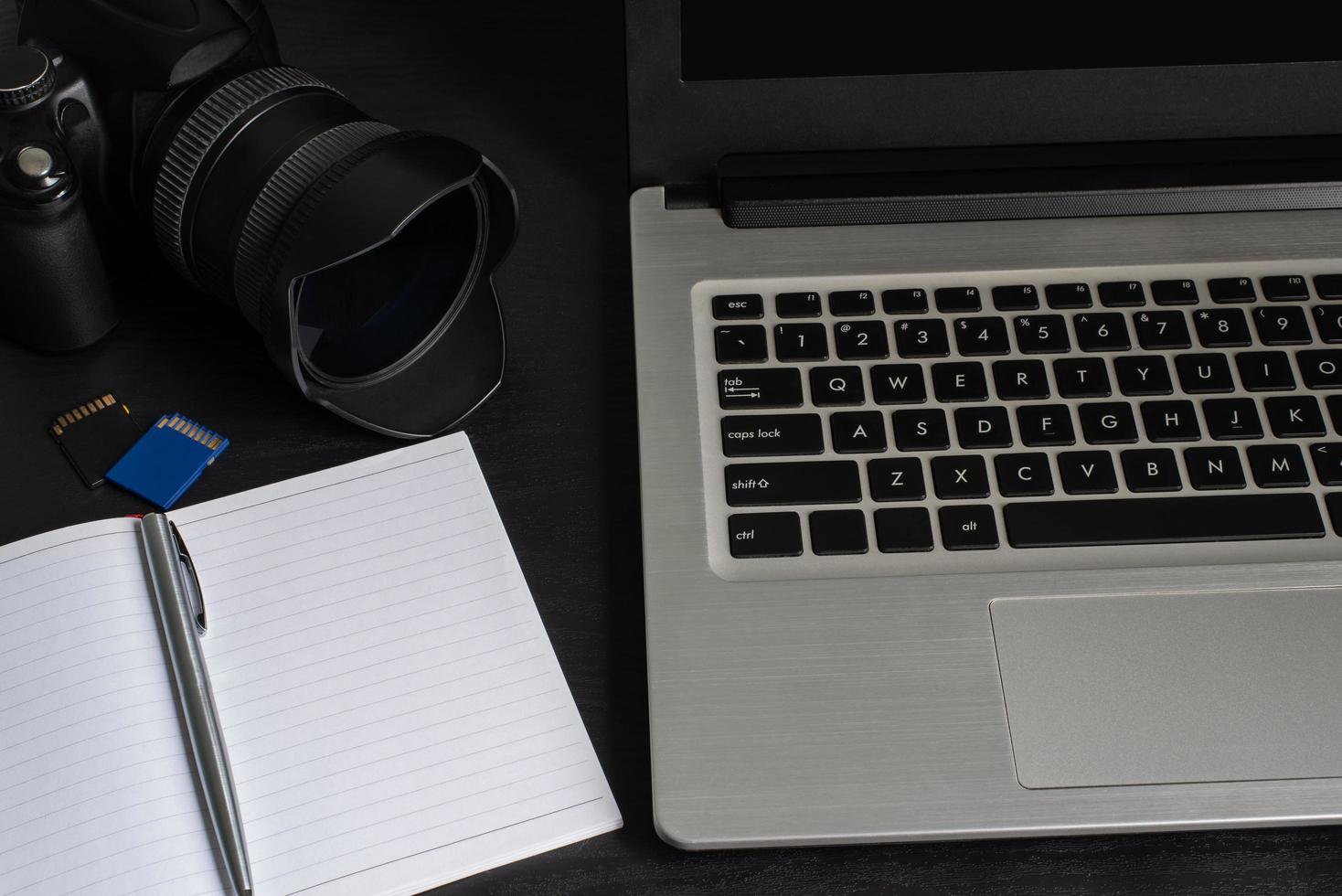 Top view laptop, camera, notebook, pen, memory card photo