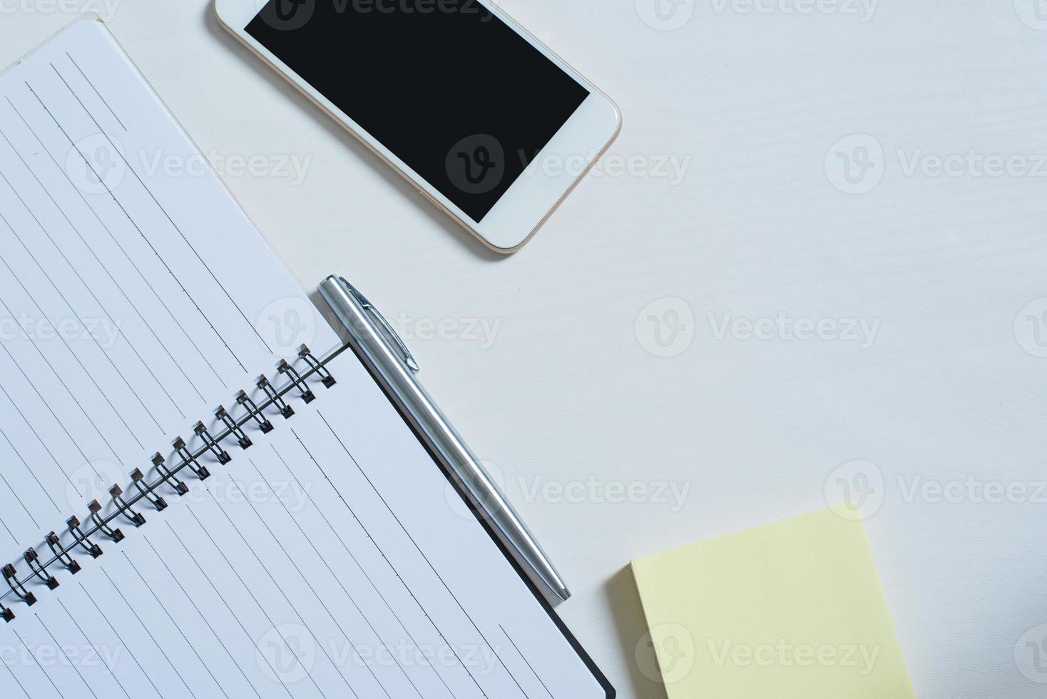 Top view of Cellphone ,  Open book, pen, papernote photo