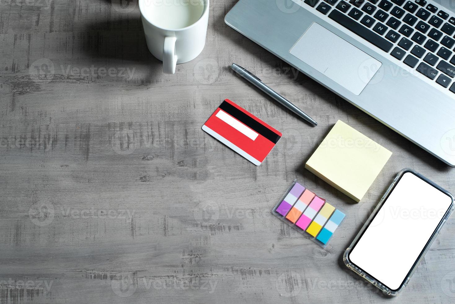 Top view of laptop, smartphone, credit card, cup of milk, paper note, pen, on wooden table with business, commerce, finance, education concept and design photo