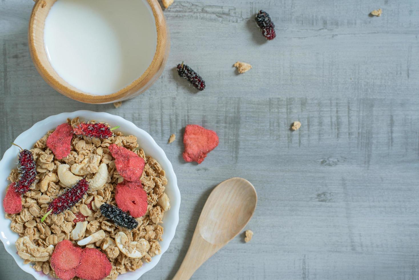 Top view of oat flakes with strawberry, mulberry, almond and milk photo