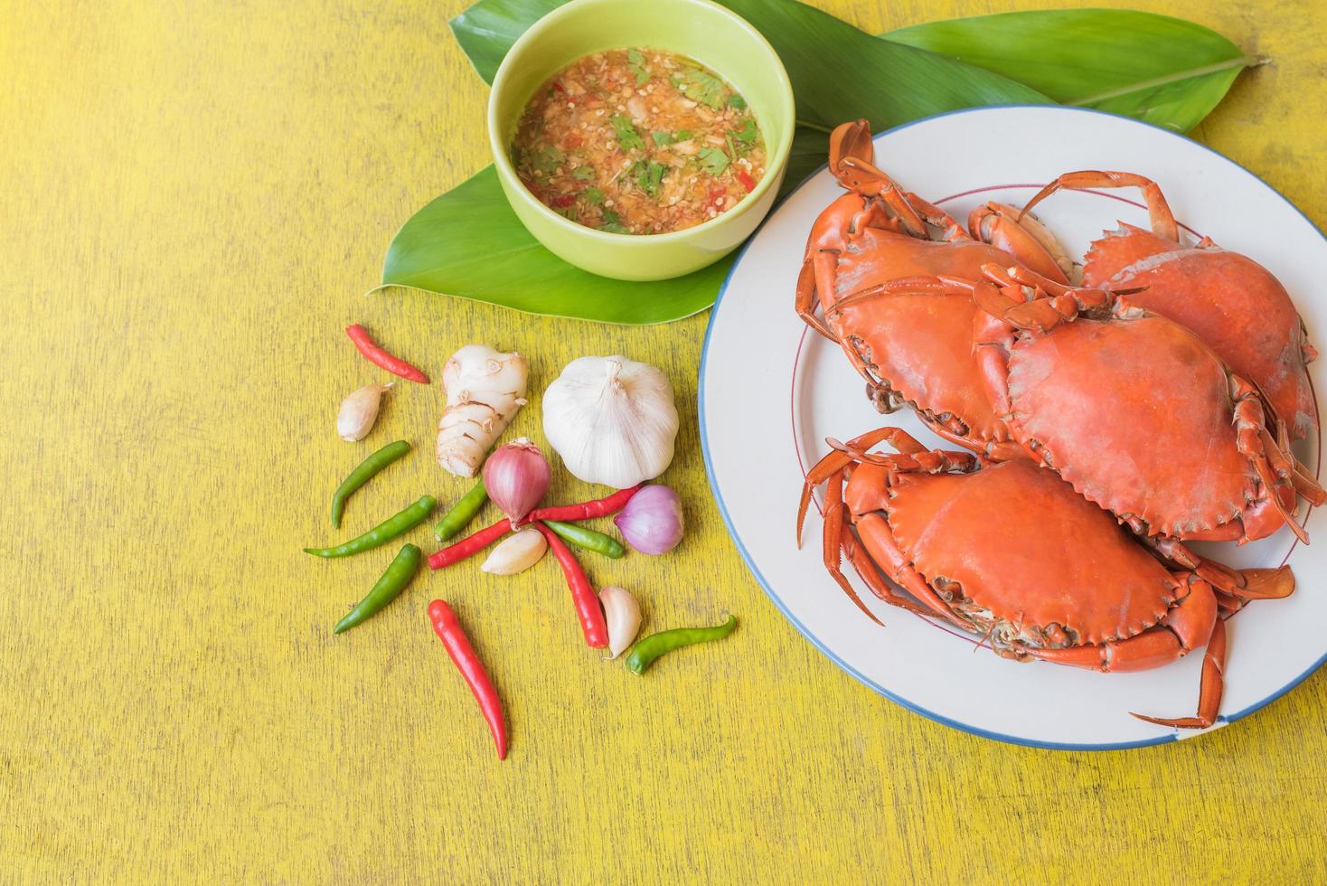 Top view of steamed crap set with seafood sauce on yellow wooden  table photo