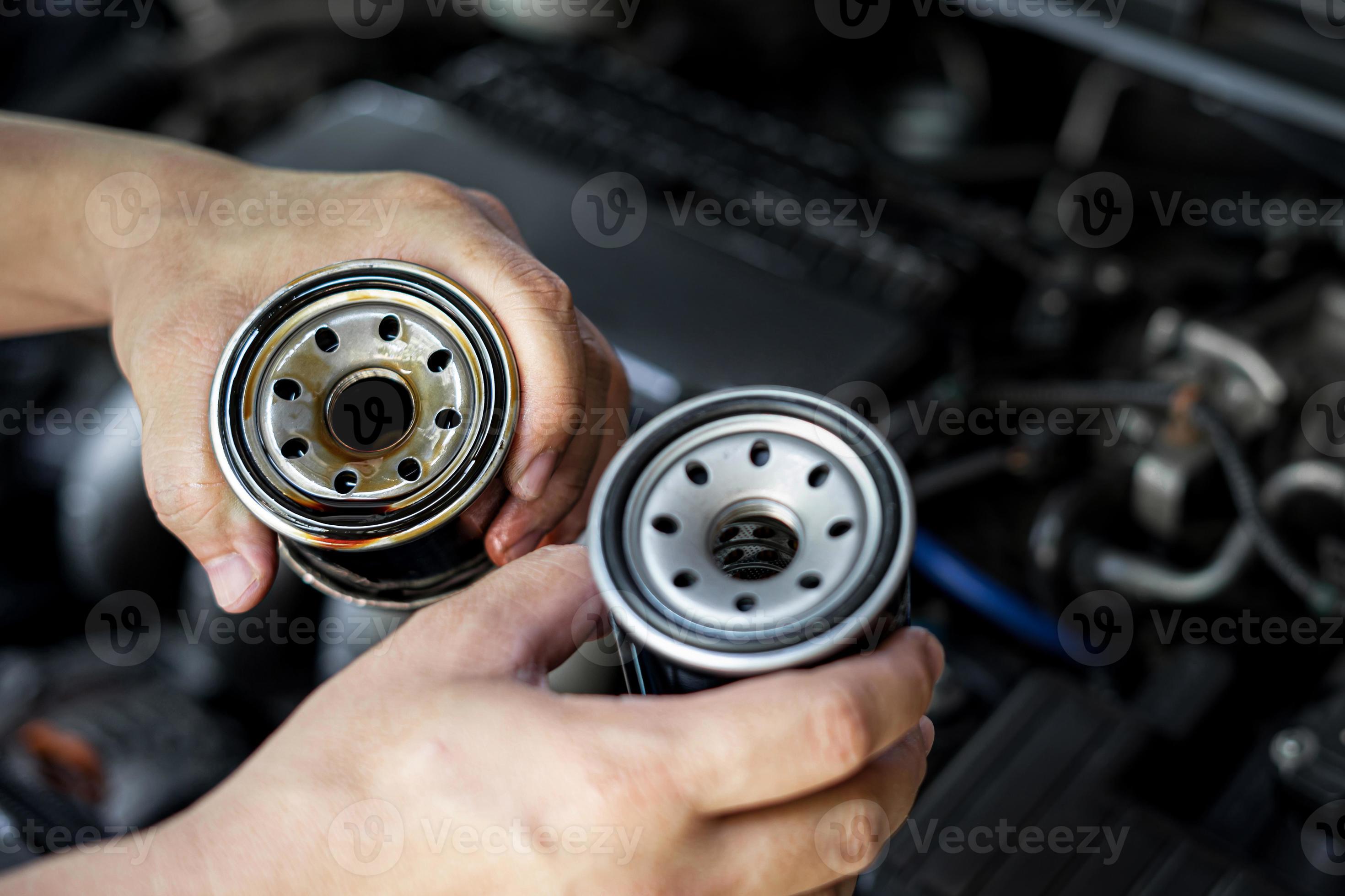 Close up used oil filter in hand a man compare with the new oil filter