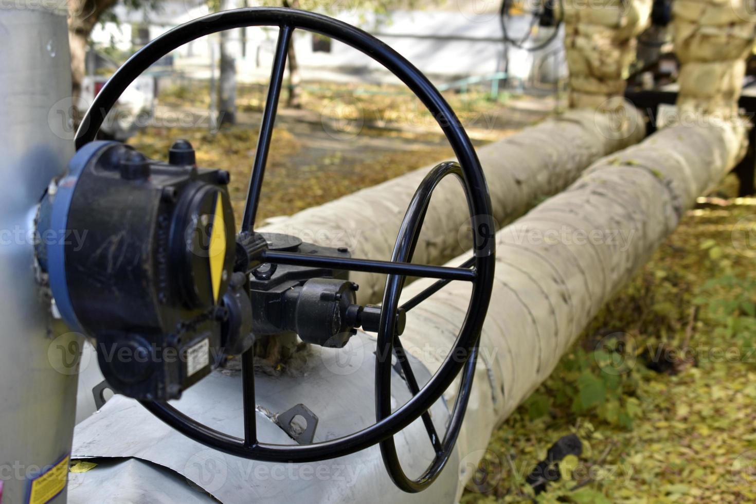 Black iron valves on the water heating main. Valves on heating pipes in the city. photo