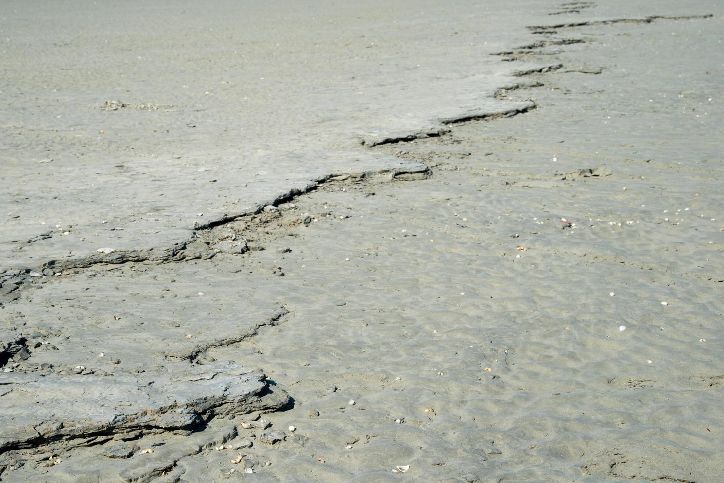 Backgrounds. Close up of a crack in a sandy surface photo