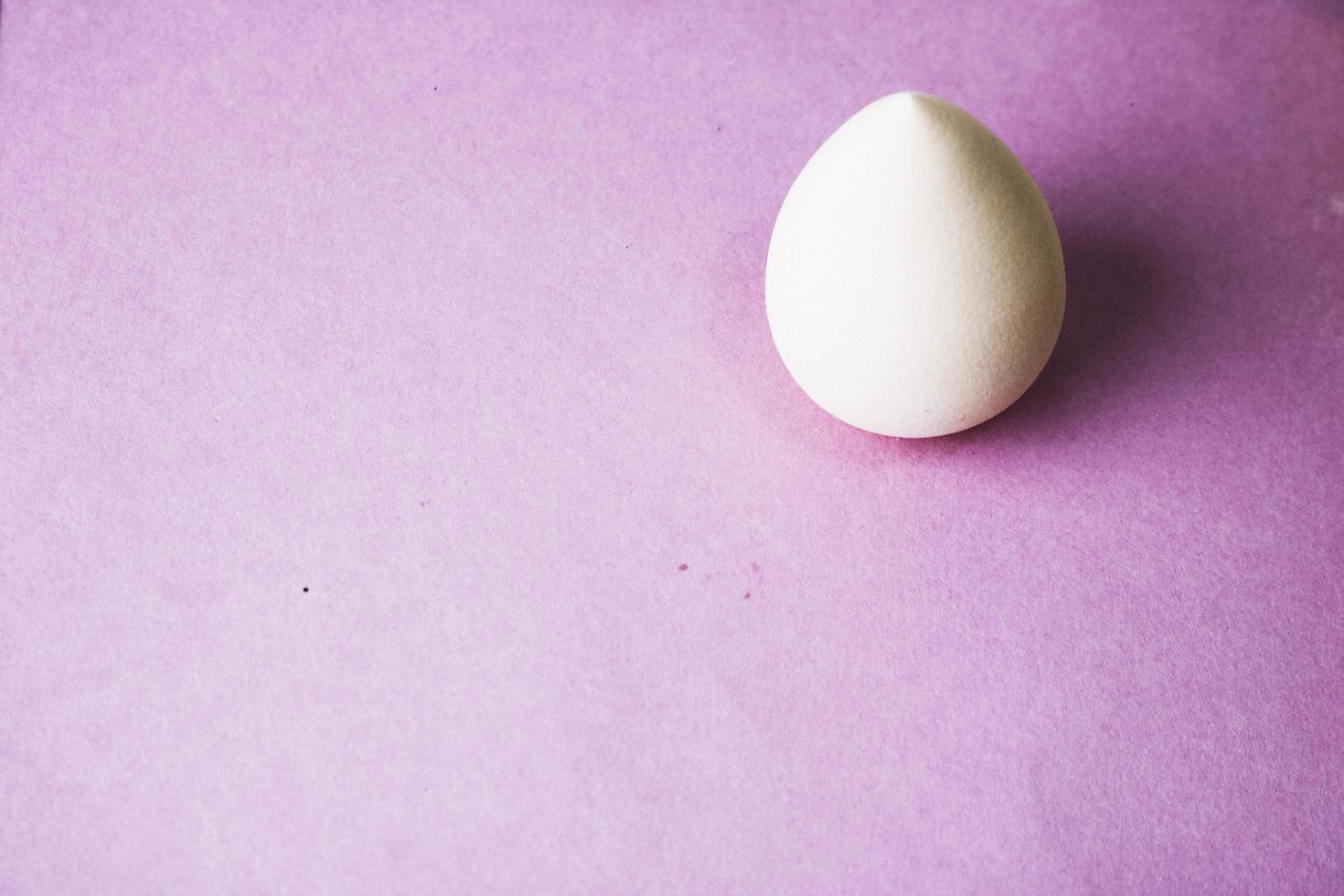 Small round beauty blender for applying tonal framework, cream, oil on the background of a cosmetic table for makeup for beauty photo