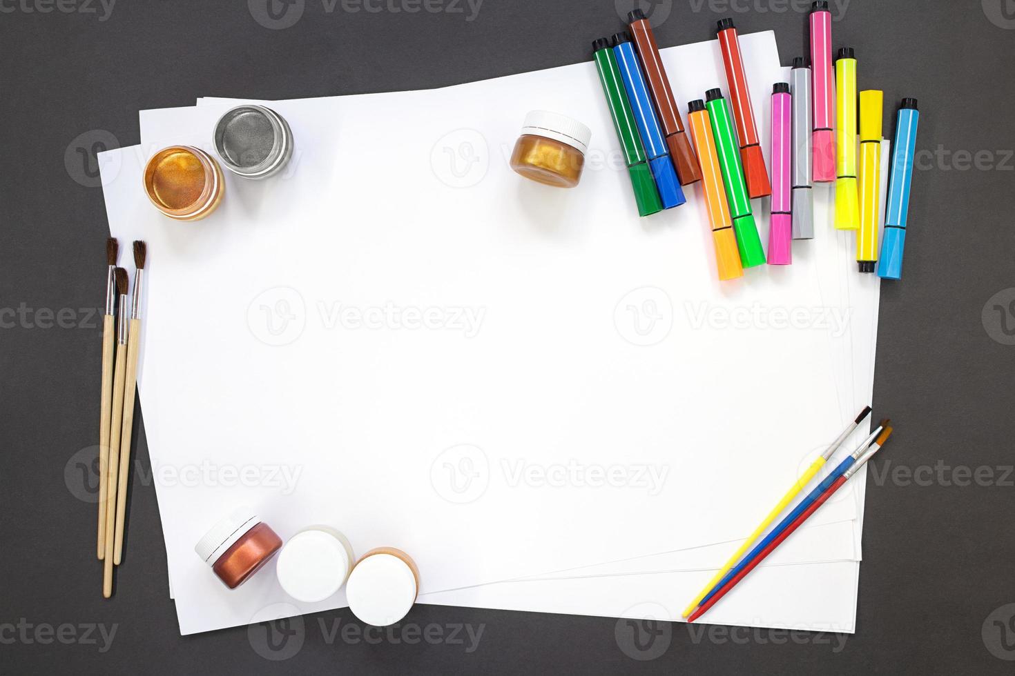 Paints, brushes, felt tip pens for drawing with white paper. Education concept, back to school. Copy space photo
