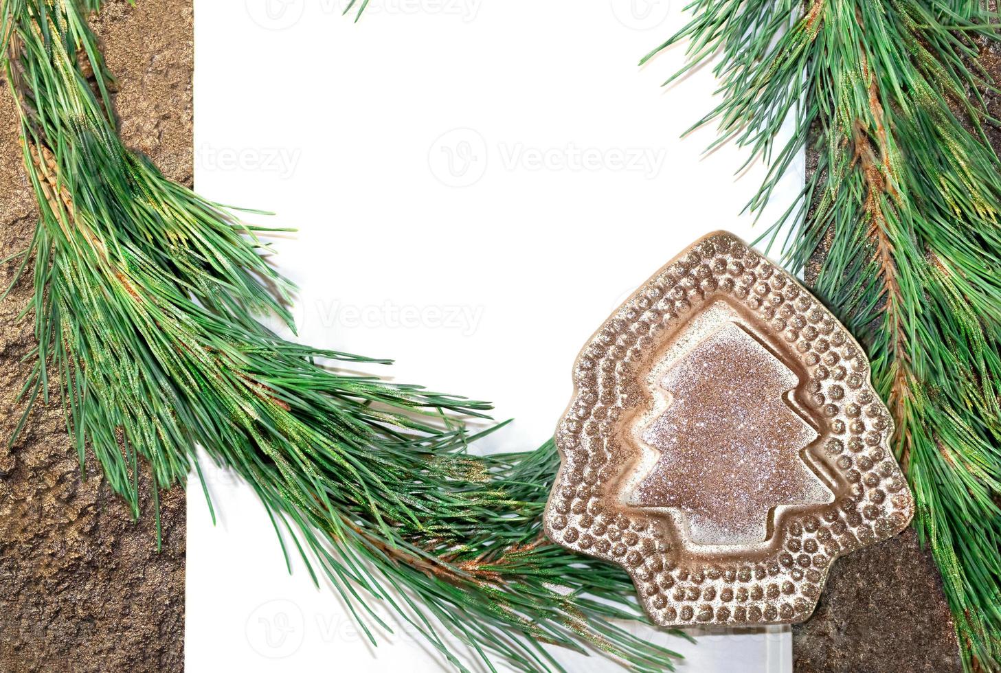 White paper with pine branches and shiny Christmas tree. Copy spase photo