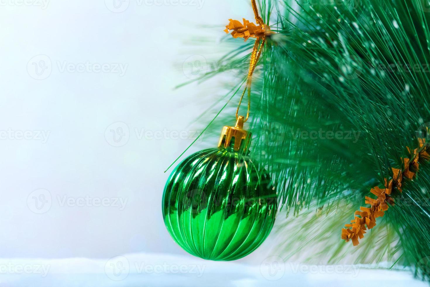 Christmas green ball on pine and snow. New year card. Copy space photo