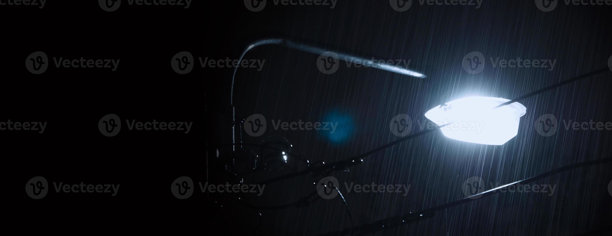 lloviendo noche y luz. gotas de lluvia cayendo en la noche en bangkok, tailandia, en la temporada de lluvias de agosto. foto