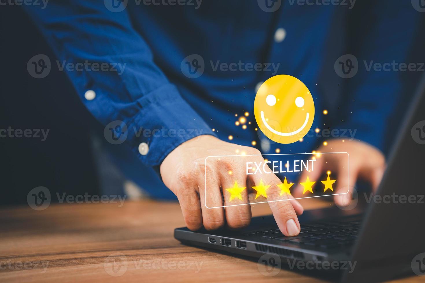 Man hand using computer laptop with popup five star icon for feedback review satisfaction service, testimonial. Customer service experience and business satisfaction survey. photo