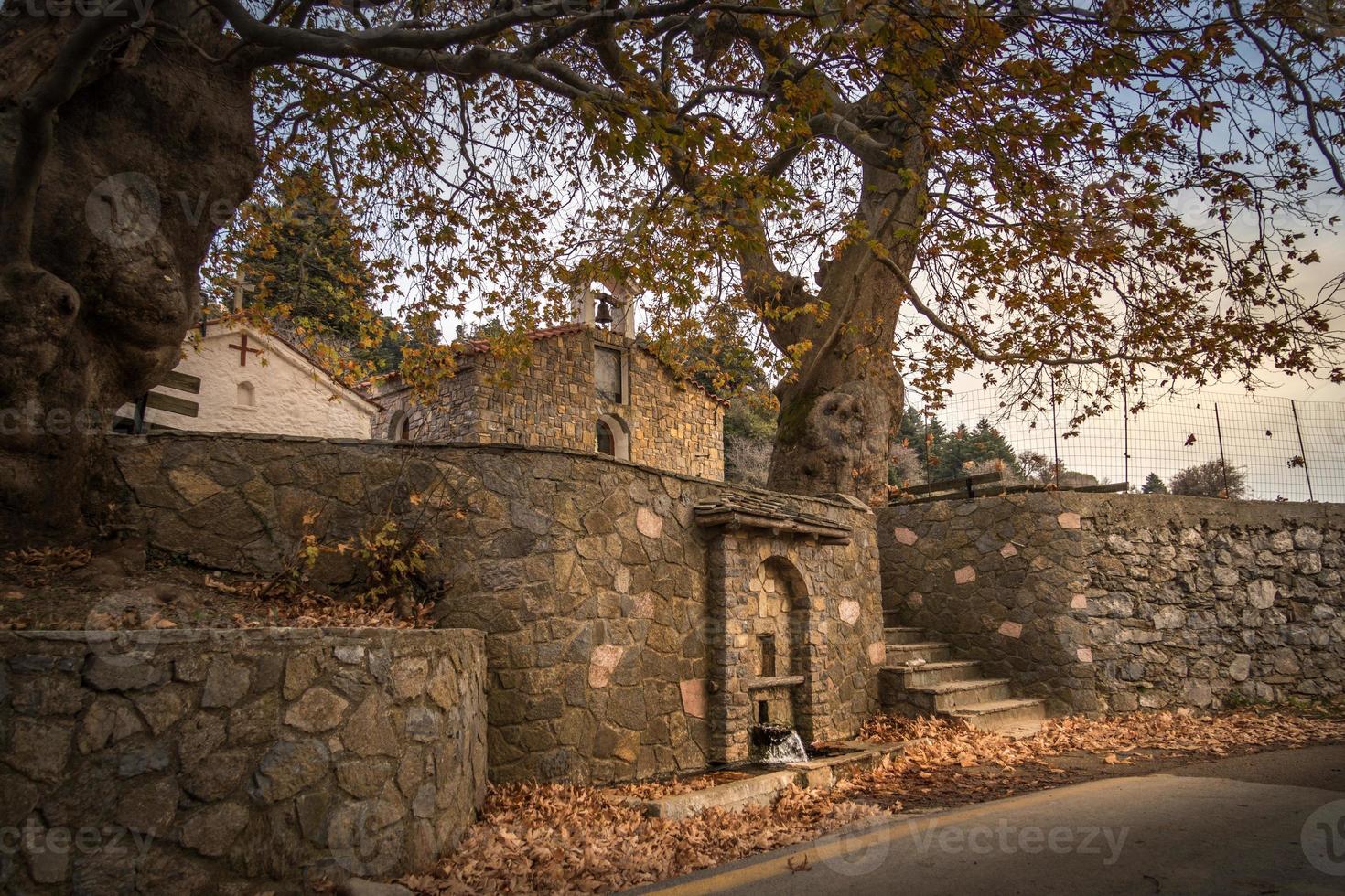 hojas de otoño junto a la fuente de piedra foto