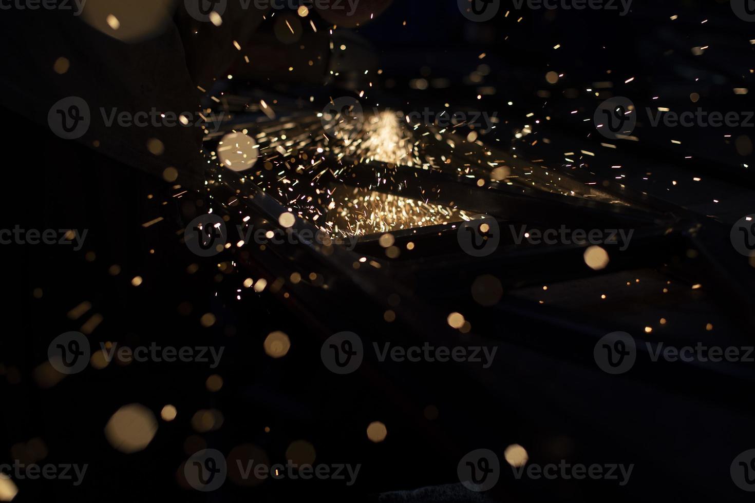 Sparks in dark. Metal grinding lights. Details of grinder's work. photo