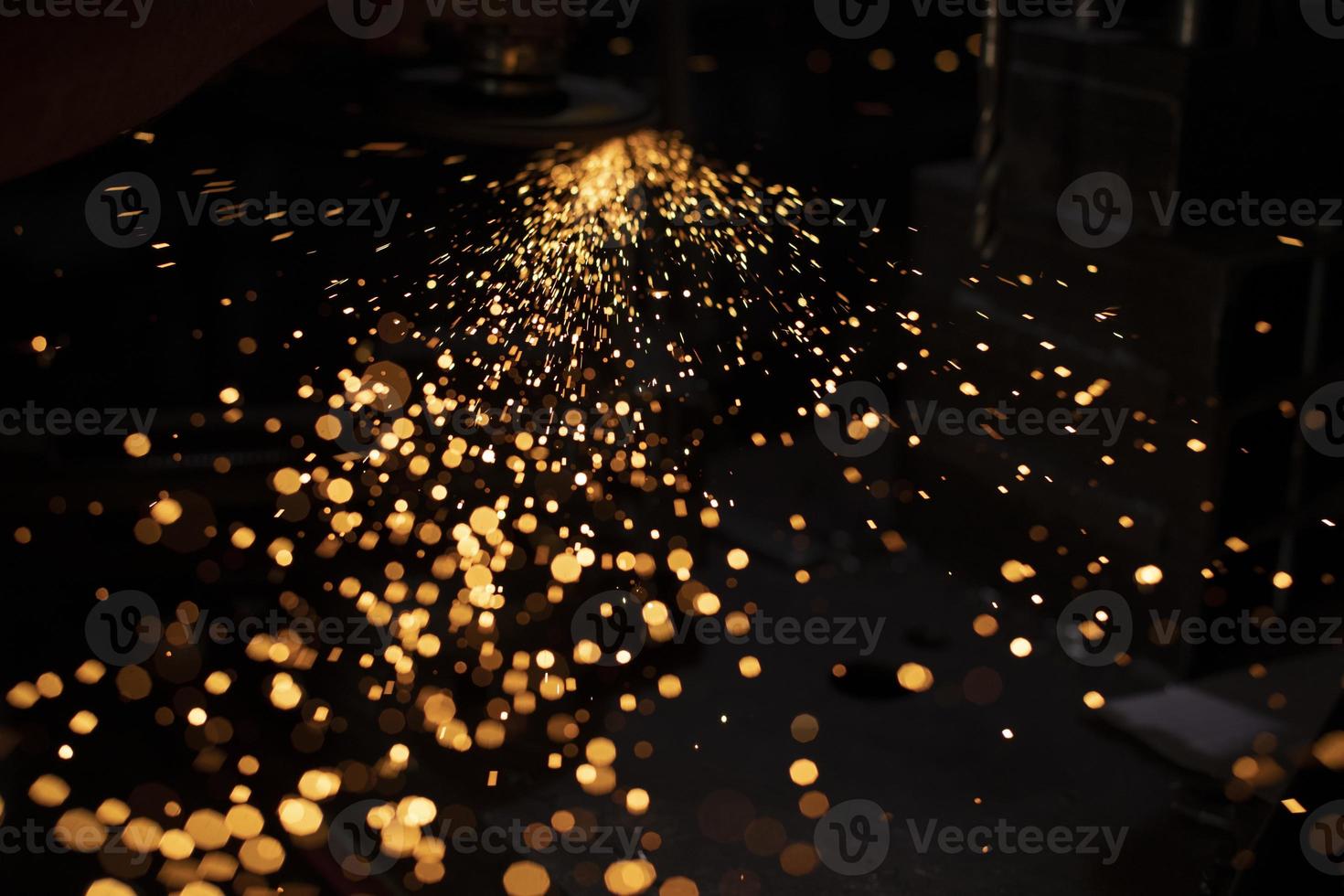 Sparks from grinding metal. Bright lights in dark. Cutting steel. Metal profile processing. photo