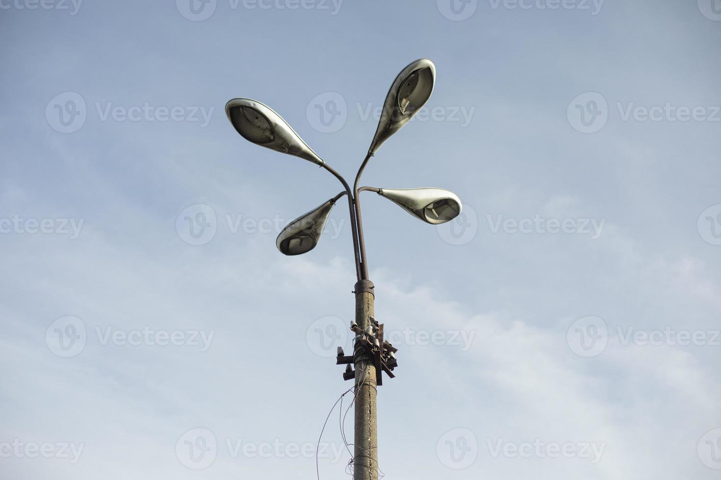 Four lamps on pole. Lighting fixture of old type. photo