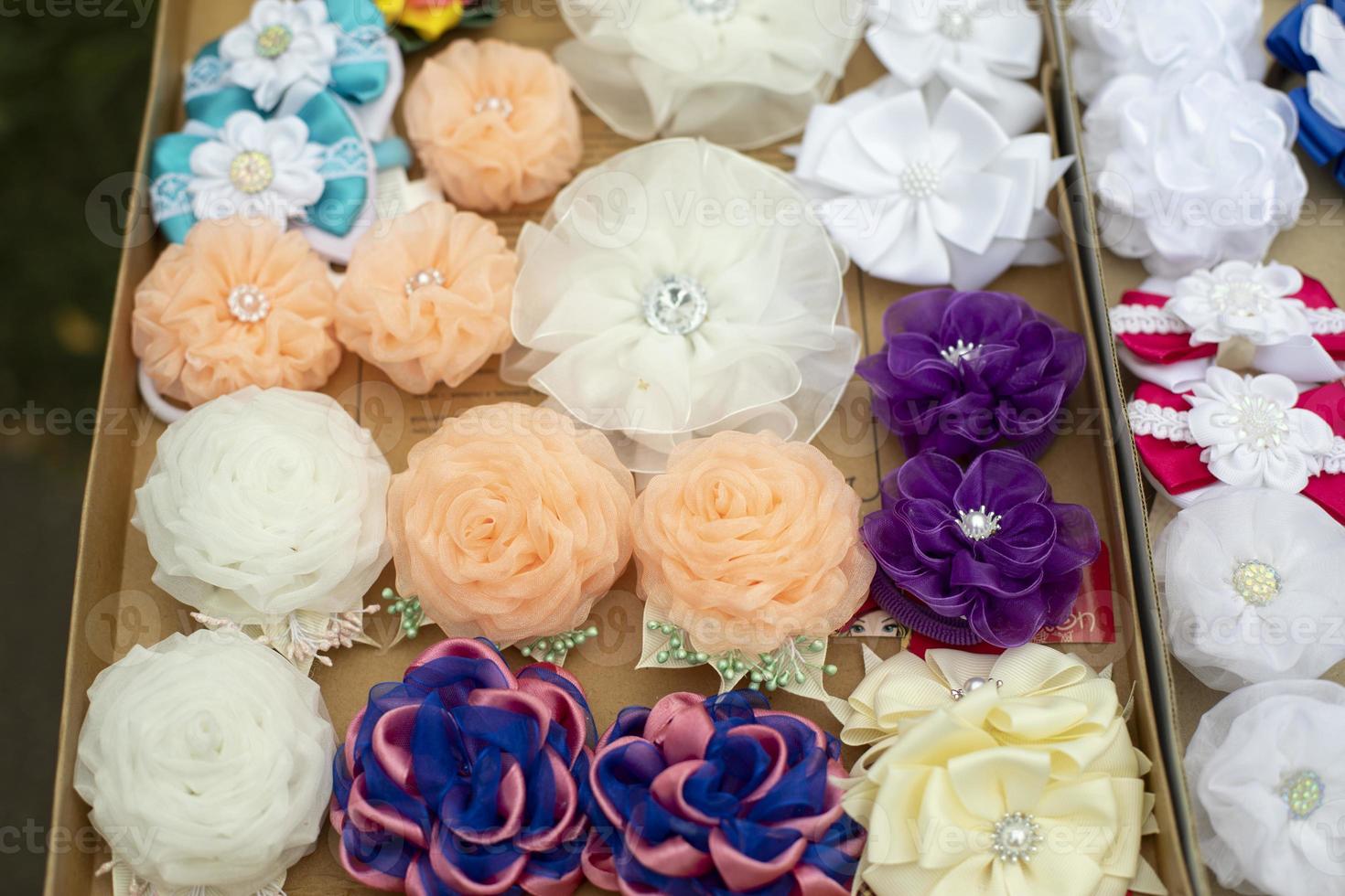 Flowers made of hair fabric. Hair clips of different colors. Fabric products for decoration. photo