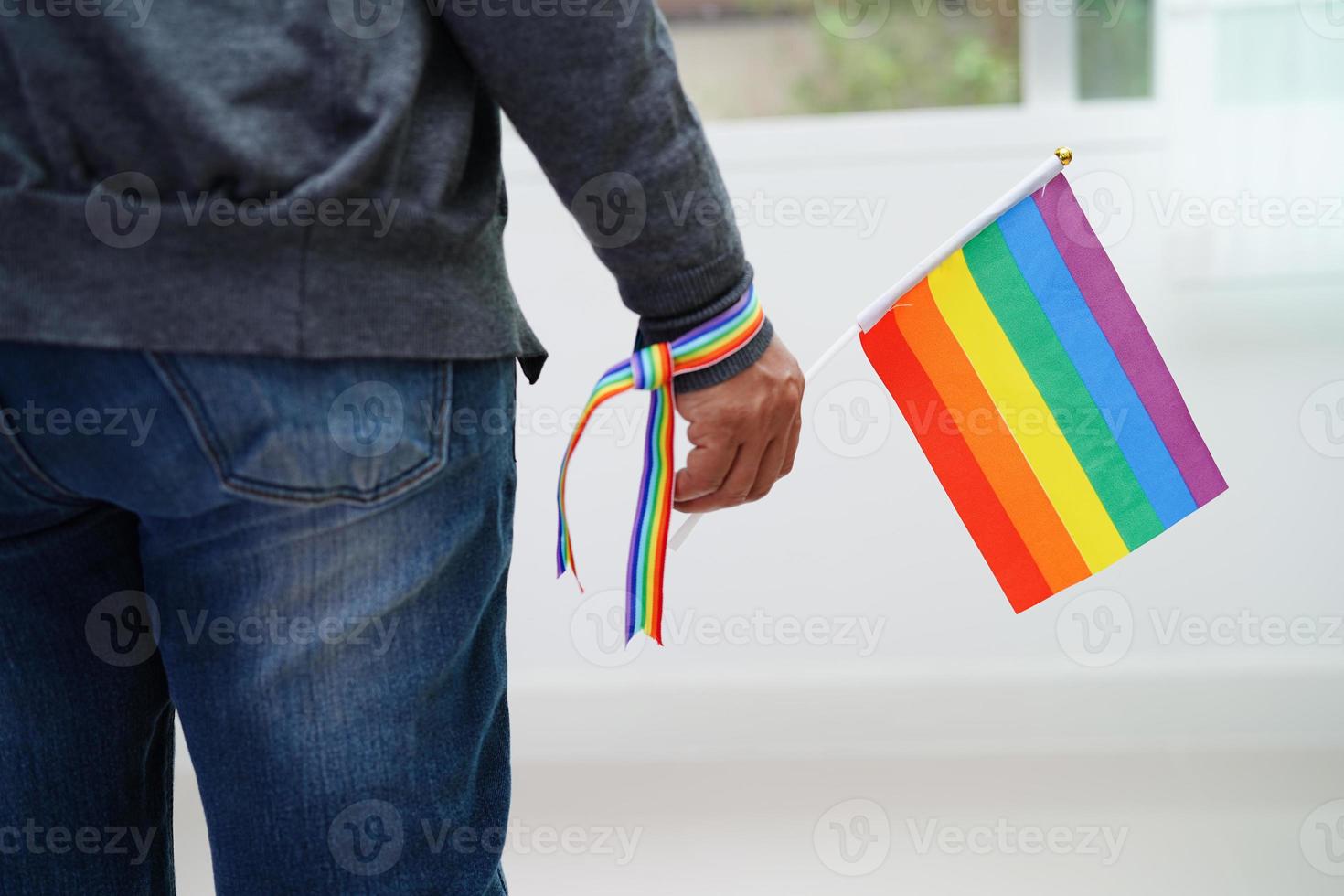 Asian woman with rainbow flag, LGBT symbol rights and gender equality, LGBT Pride Month in June. photo